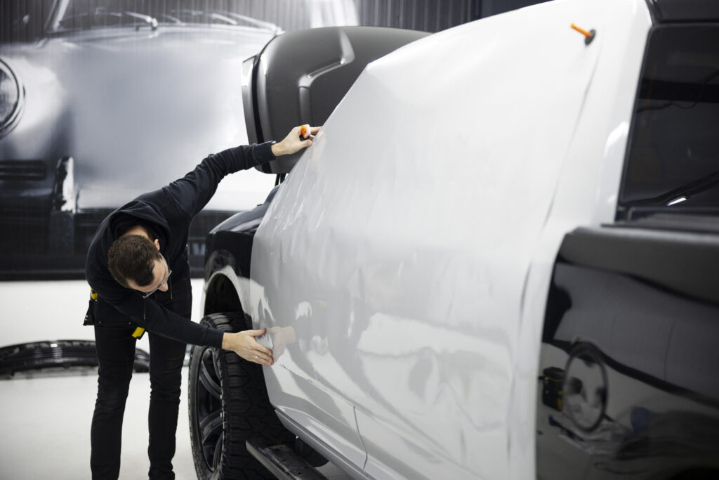 full shot man wrapping car