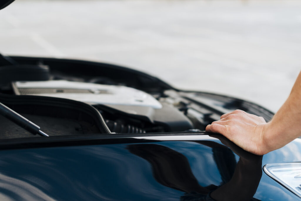 man leaning car with open hood